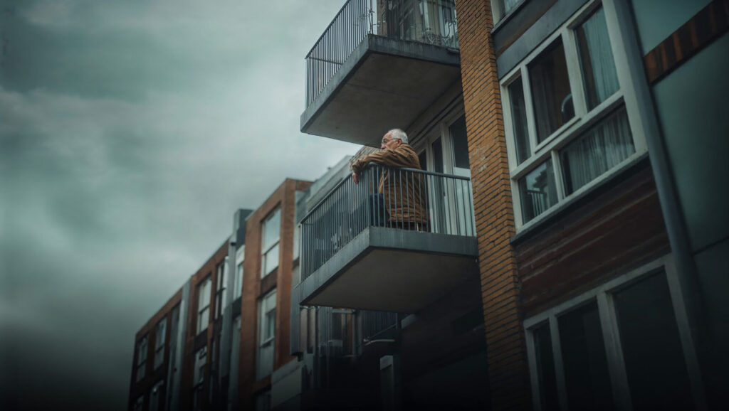 Homme âgé seul sur son balcon